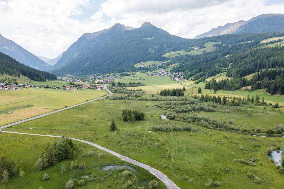 Weißpriach von oben: Die Longa zieht sich durch die weite Tallandschaft und begleitet uns auf der Bike-Etappe.