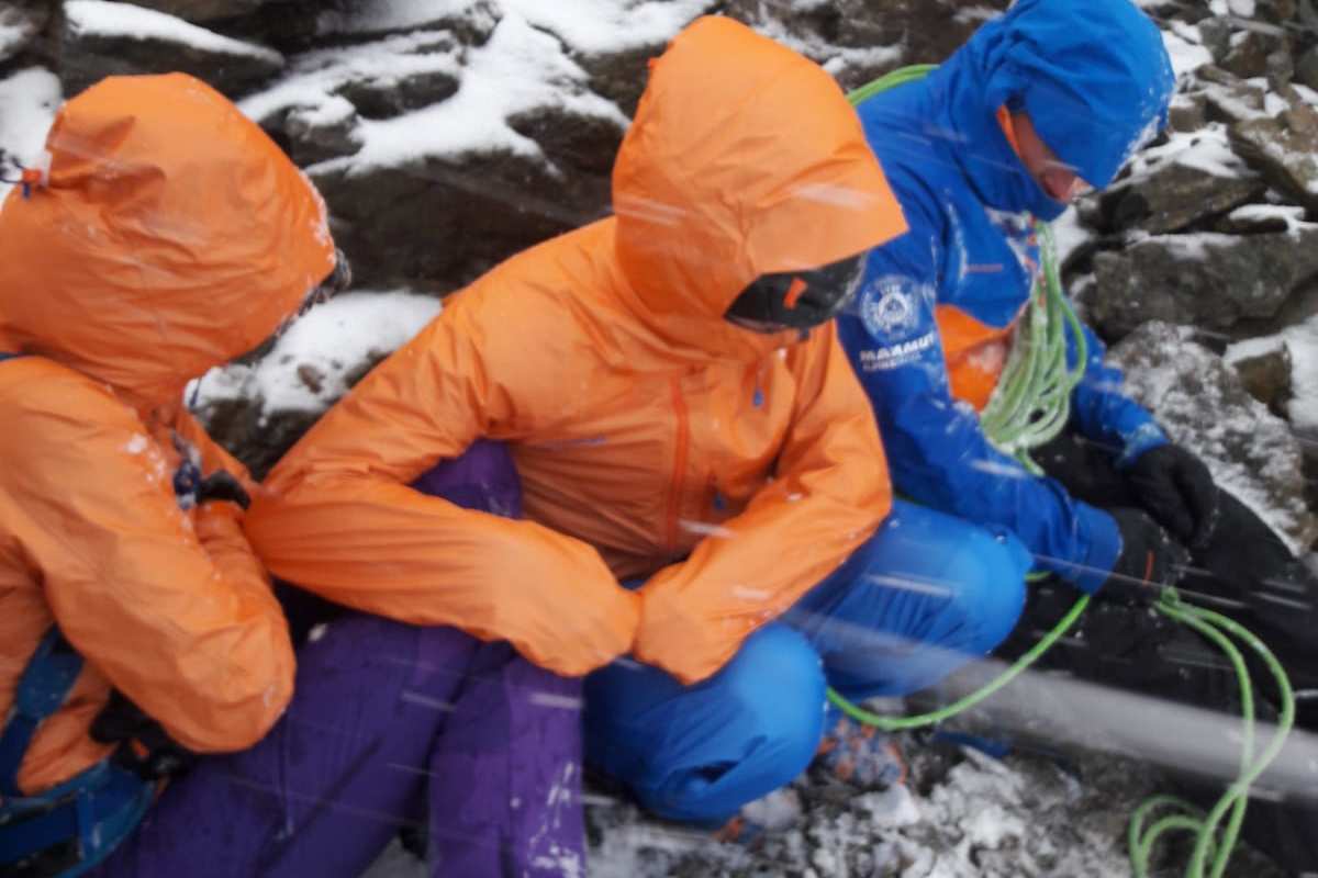 Die Teilnhemer harren am Fuß der Eigerjöcher aus, während ihnen der Wind um die Ohren pfeift