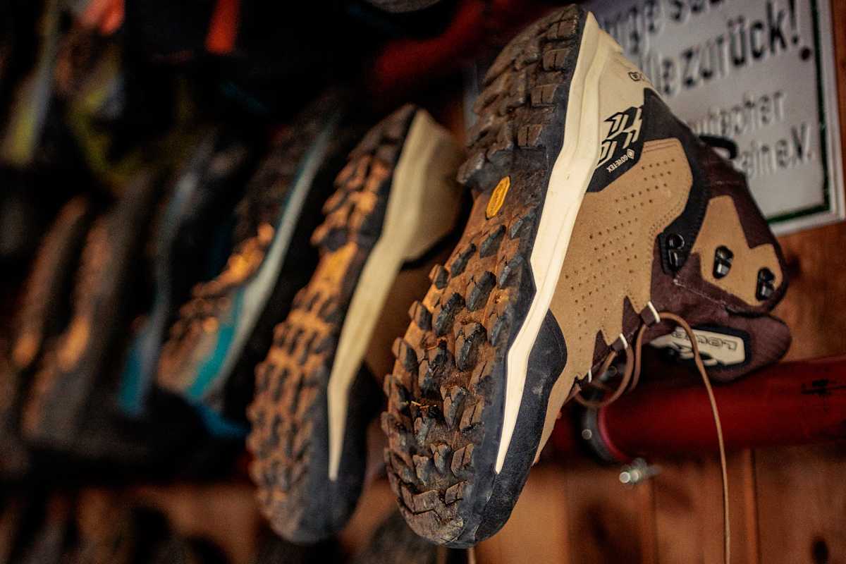 Der LOWA® EXPLORER GTX MID hängt zum Trocknen auf einem Holzgeländer.