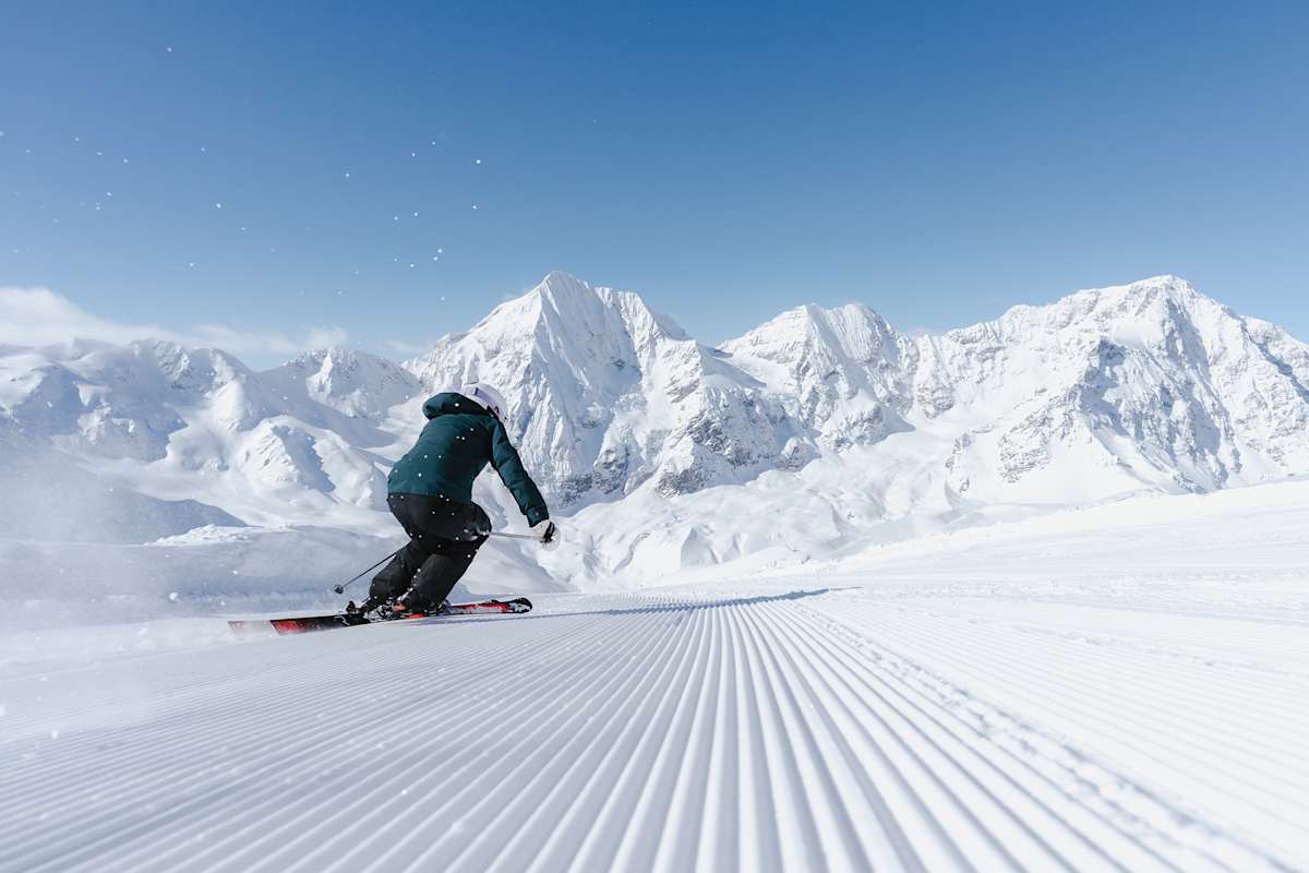 Ein Skifahrer fährt auf einer perfekt präparierten Piste den Hang im Skigebiet Sulden hinab.