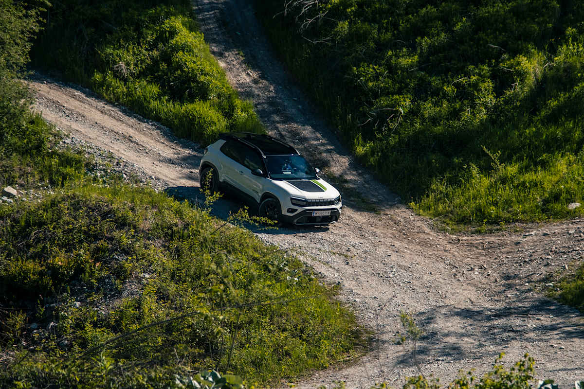 Der Jeep Avenger 4xe beim Bergabfahren auf einer Schotterstraße.