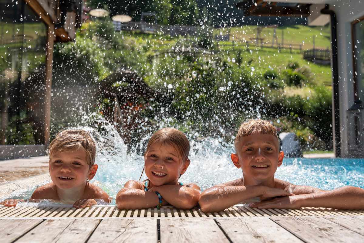 Kinder platschen im Schwimmbecken