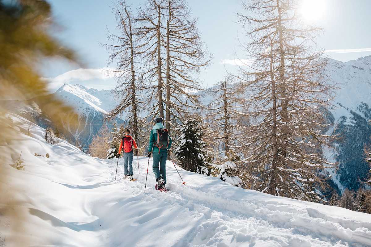 Ein verschneiter Pfad, der sich durch stille Wälder schlängelt - jeder Schritt knirscht im Schnee, während die Landschaft in frostigem Glanz erstrahlt.