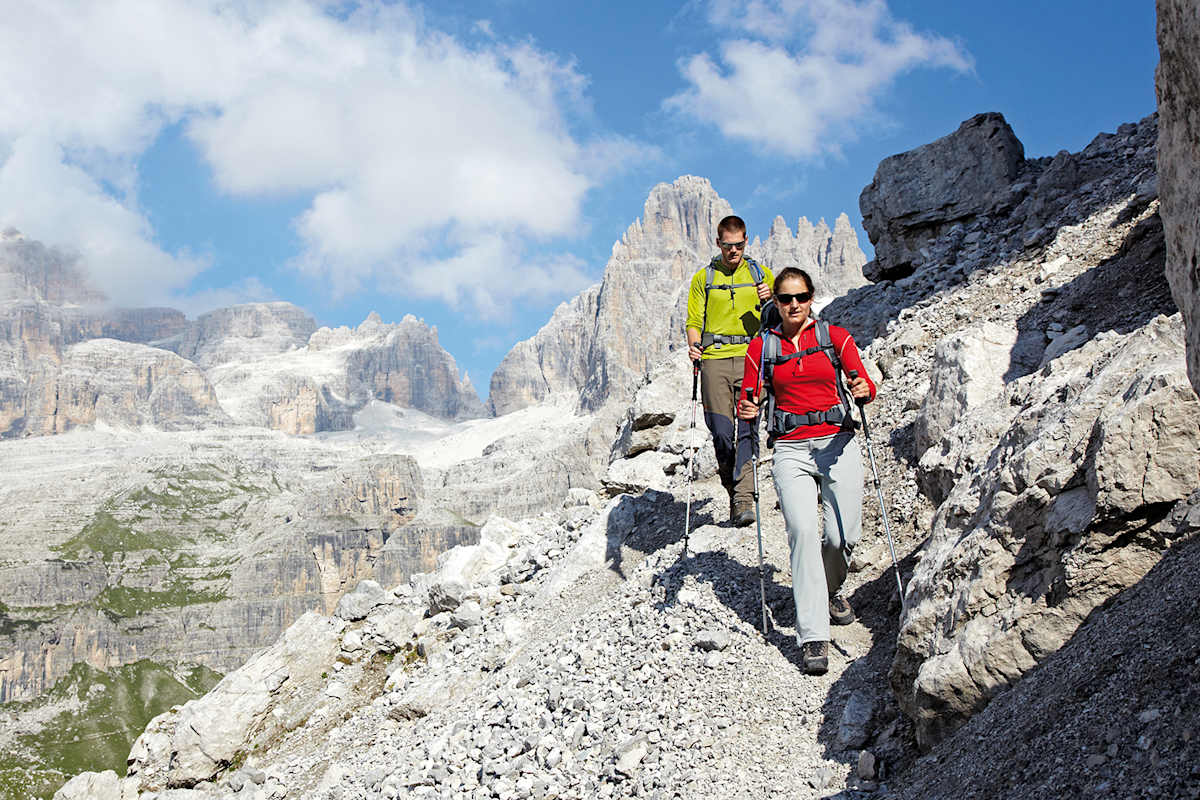 Zwei Wanderer unterwegs im schroffen Hochgebirge der Dolomiten.