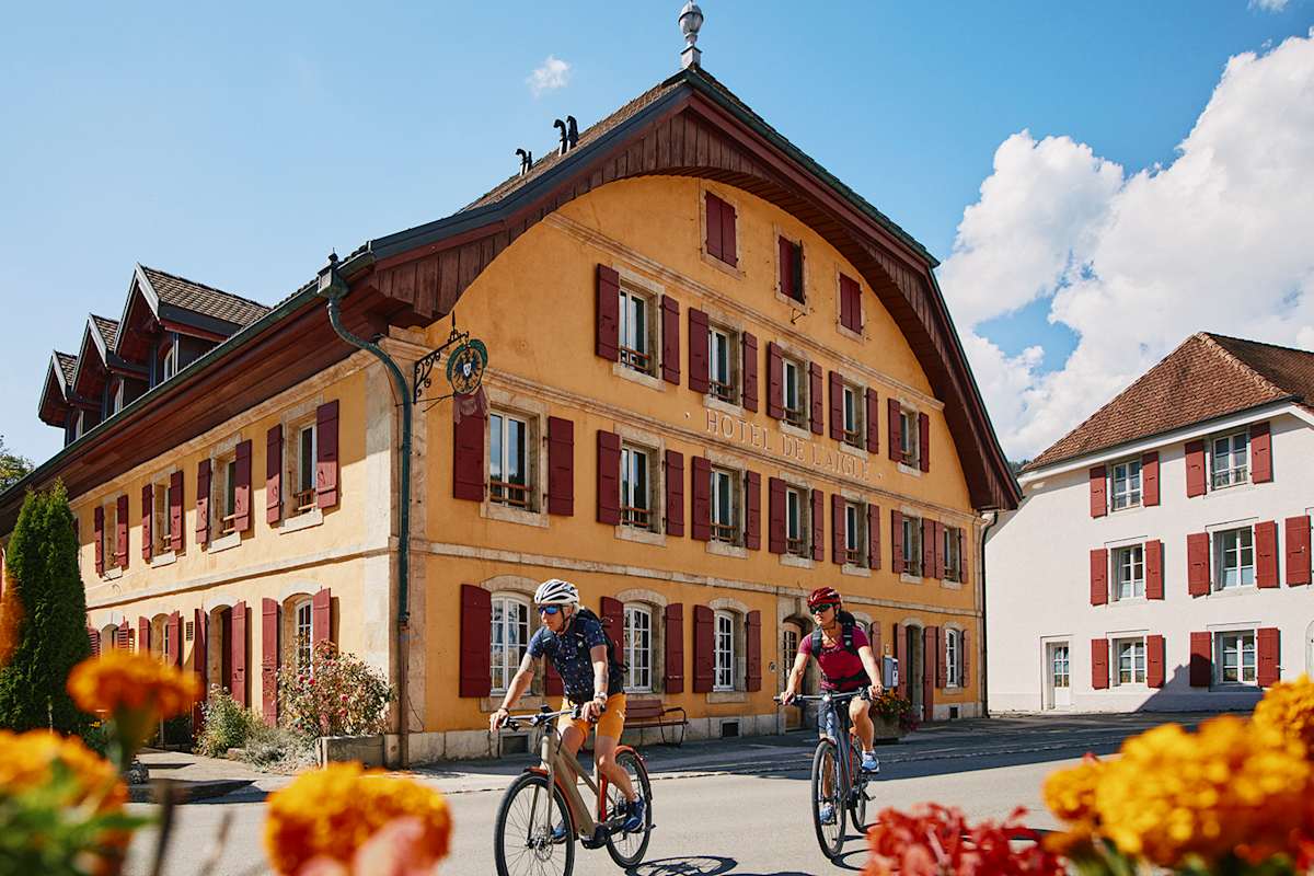 Zu sehen ist ein rustikales, gelb gestrichenes Gasthaus.