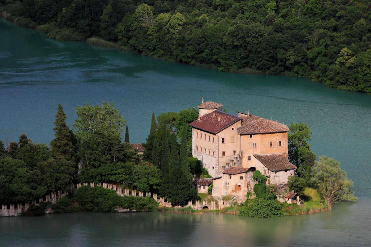 Ein Schloss auf einer kleinen, grünen Insel im Lago di Toblino.