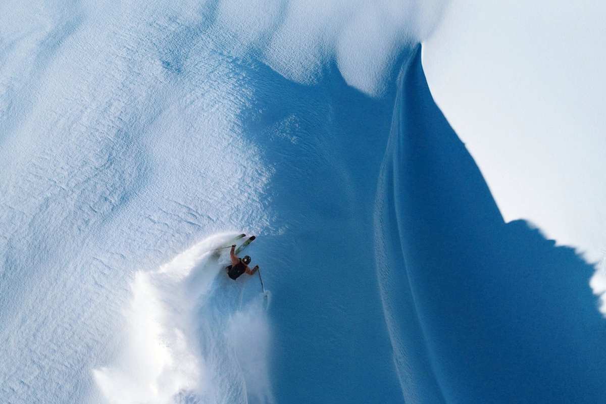 Ein Freerider zieht Schwünge in den Schnee.
