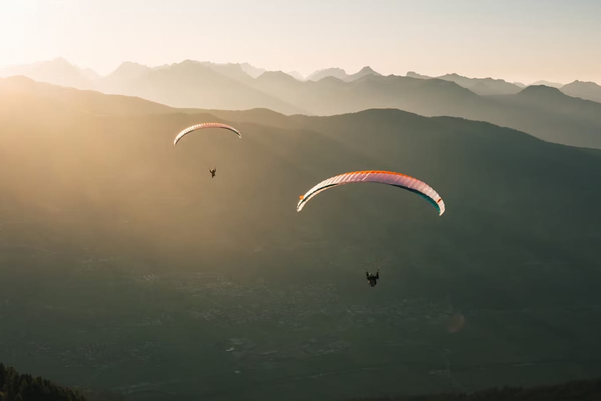 Zwei Paragleittschirme in einer Bergwelt