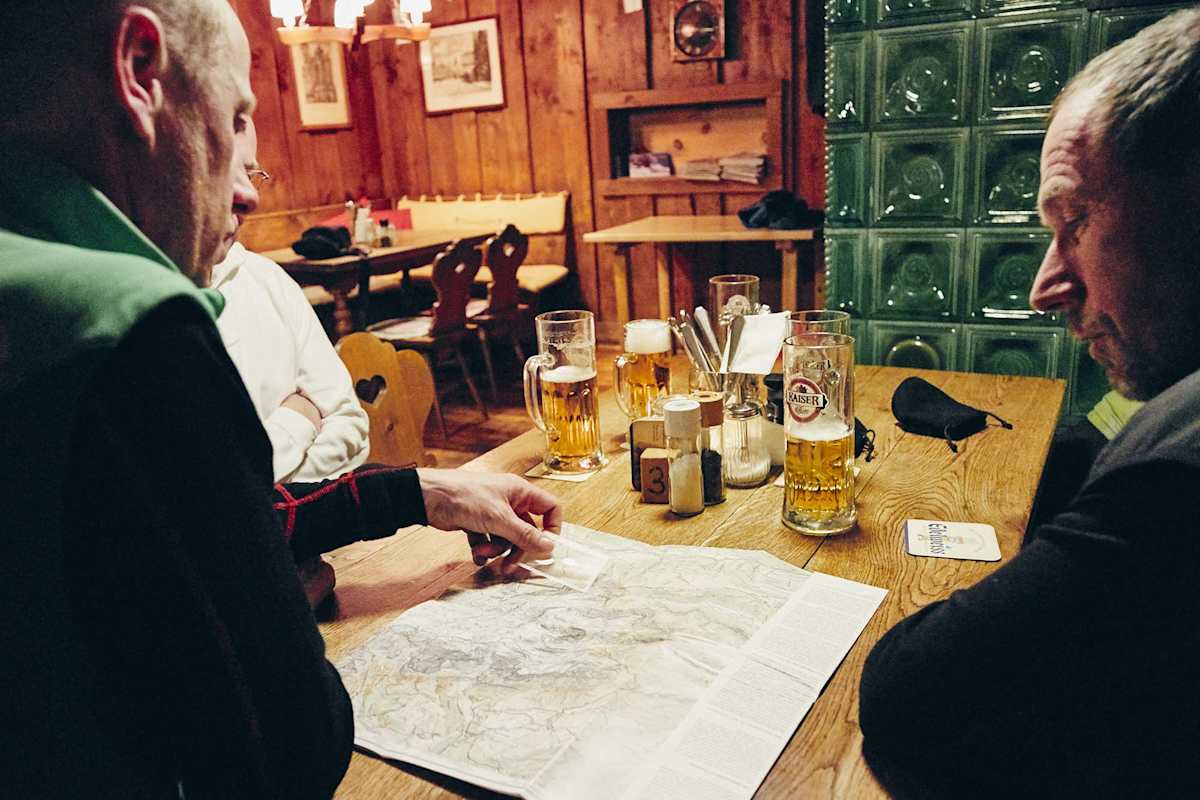 Die Crew sitzt vor einen Karte in der gemütlichen Stube der Ostpreußenhütte.
