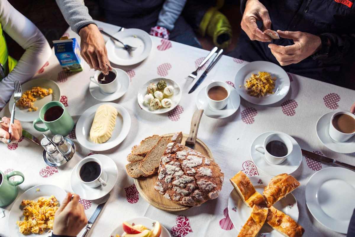 Ein gedeckter Frühstückstisch voller Köstlichkeiten wie Bauernbrot, Butter und Kaffee.