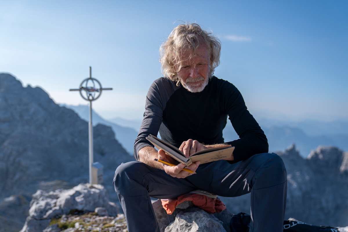 Der Tiroler Alpinist Adi Stocker hat sein Leben den Steinbergen verschrieben – hier sitzt er am Gipfel des „Nackten Hunds"