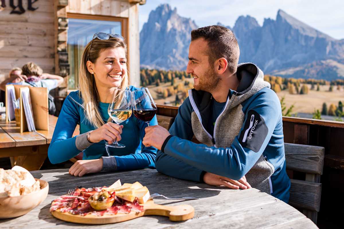 Bei einem Glas jungem Wein und einer Brettljause lässt sich der Herbst auf der Seiser Alm besonders gut genießen.