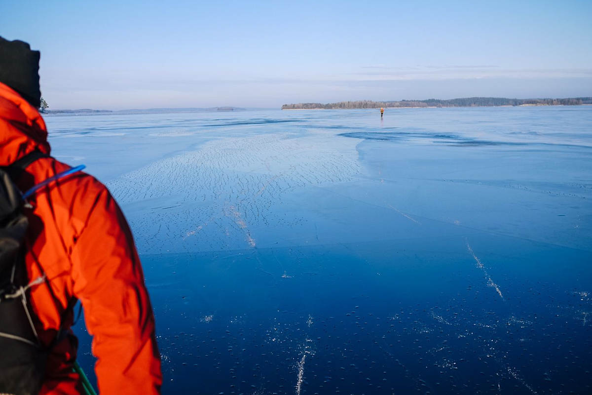 Blauer Himmel und blaues Eis in Schweden mit Anschnitt eines Nordic Skaters