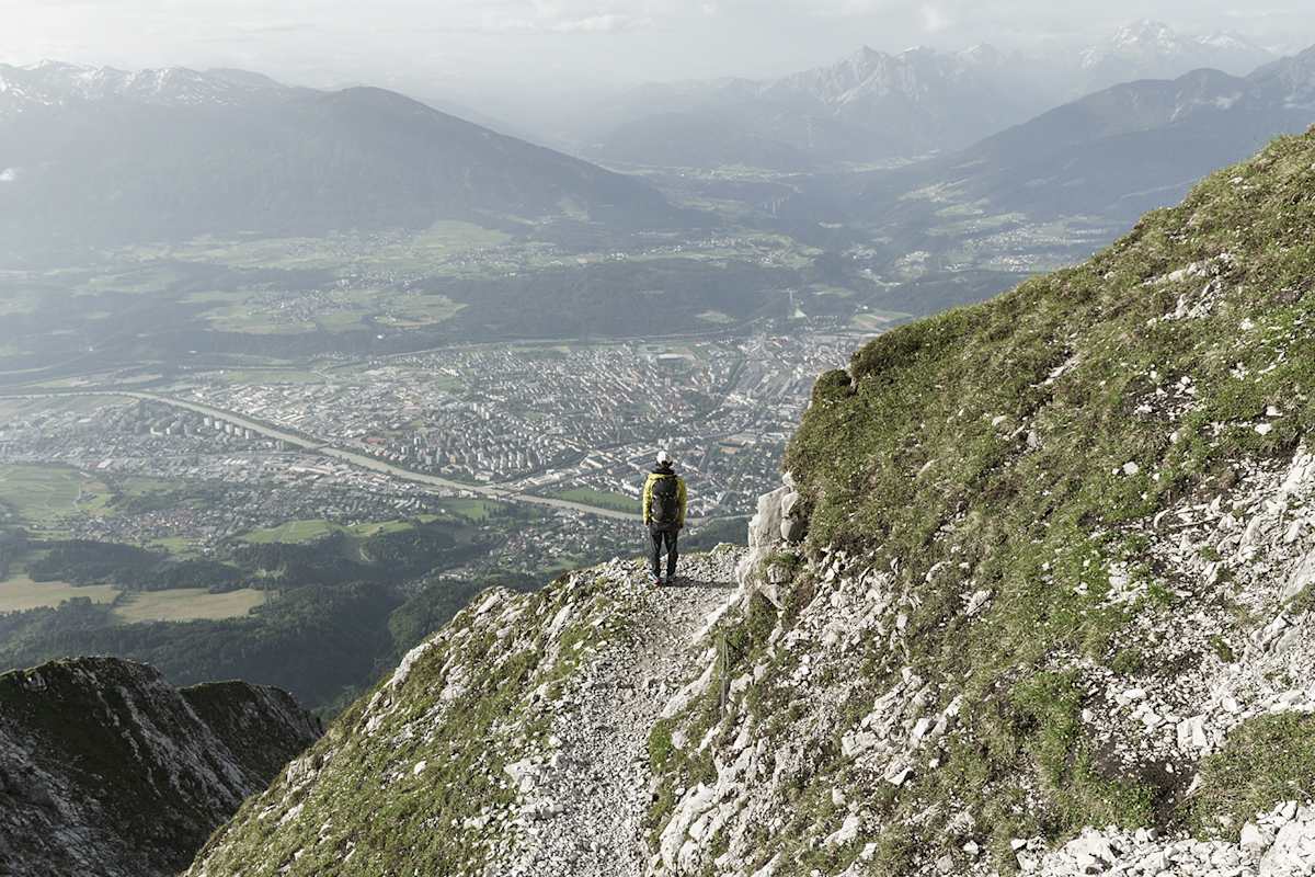 Mann steht auf Berg und blickt in Richtung Innsbruck