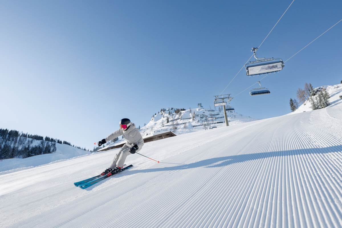 Ein Skifahrer carvt auf einer frisch präparierten Piste auf der Hermann Maier Tour im Snowspace Salzburg.