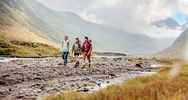 Zwei Frauen und ein Mann sind mit dem LOWA® EXPLORER GTX auf Tour.