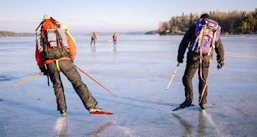 Zwei Nordic Skater mit Rucksäcken auf einem gefrorenen See nahe Uppsala