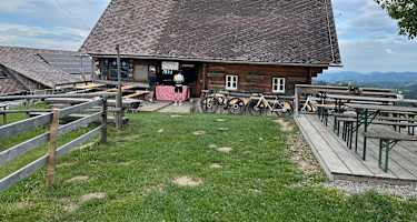 Almhütte Remschniggalm in der Südsteiermark mit Tischen und Bänken