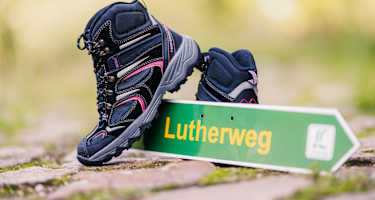 Lutherweg Sachsen Schild und Wanderschuhe