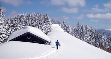 Verschneite Holzhütte entlang des Aufstiegs