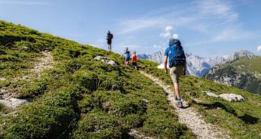 Familienwanderung im Gaistal: Familie läuft auf schmalem Steig