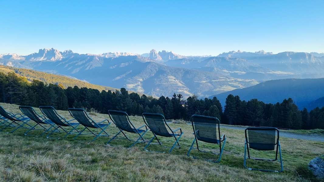 Parade der Liegestühle vor dem Panorama der Dolomiten.