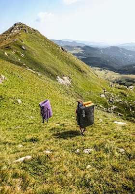 Mit den Crashpads am Rücken suchen die Kletterer die Felsen
