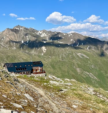 Badener Hütte in Osttirol - im Hintergrund die zum Teil noch schneebedeckten Berge