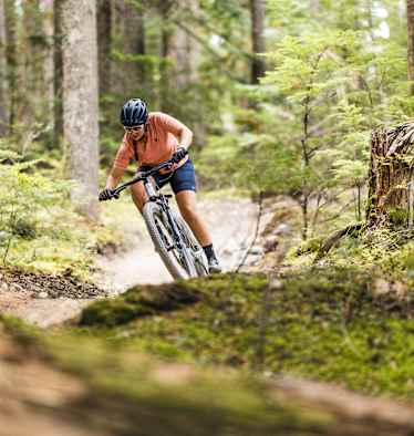 Mountainbikerin fährt durch Wald
