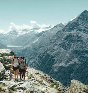 Zwei Frauen und ein Mann wandern auf dem Almageller Höhenweg.