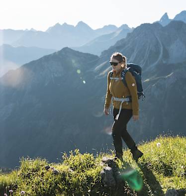 Eine Wanderin vor einer Bergkulisse.