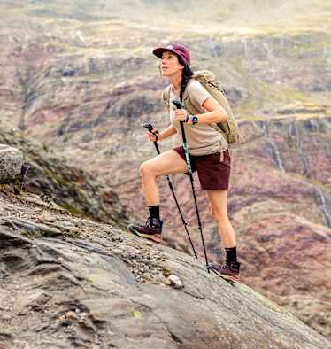 Eine Outdoor-Enthusiastin geht einen Fels hoch und trägt dabei den den LOWA® EXPLORER GTX MID Ws.