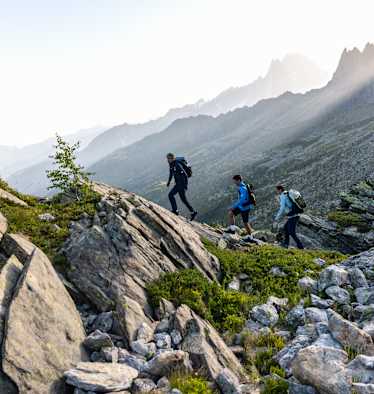 Zwei Männer und eine Frau gehen eine Tour auf einem panoramareichen Weg und tragen dabei den Ducan III Low LTH GTX.