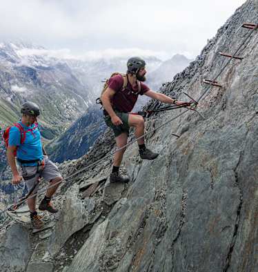 Zwei Kletterer steigen auf den Mittaghorn Klettersteig im Saastal.