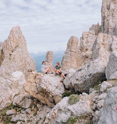 Eine Frau und ein Mann sitzen auf einem Felsen im Eggental.