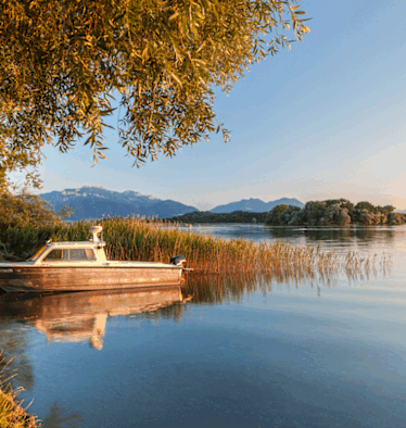 Campen am bayerischen Chiemsee mit den Chiemgauer Alpen und der Fraueninsel im Hintergrund