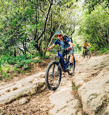 Frau fährt auf einem Mountainbike bergab