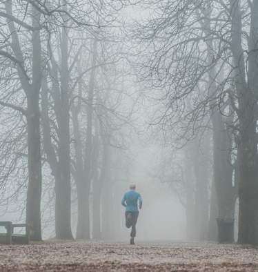 Läufer bei Nebel im Park