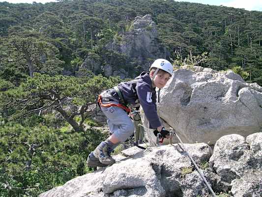 Kind klettert am Fels im Mödlinger Klettersteig