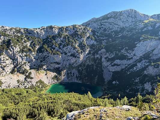 Der glasklare Silberkarsee leuchtet zwischen Fels und Latschen intensiv grün.