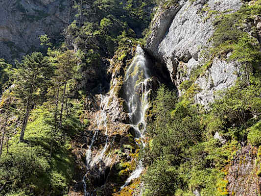 Am oberen Ende der Klamm stürzt das Wasser über die bewachsenen Felsen.