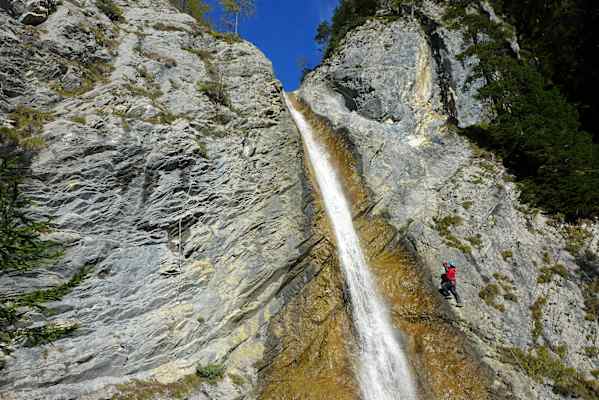 Kletterer neben einem Wasserfall im Millnatzenklamm-Klettersteig
