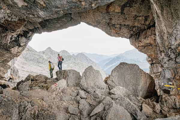 Zwei Personen gehen durch das Melkerloch beim Anstieg zum Birnhorn in den Leoganger Steinbergen