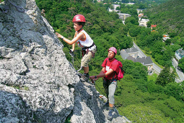 Kind und Mann klettern am Fels im Mödlinger Klettersteig