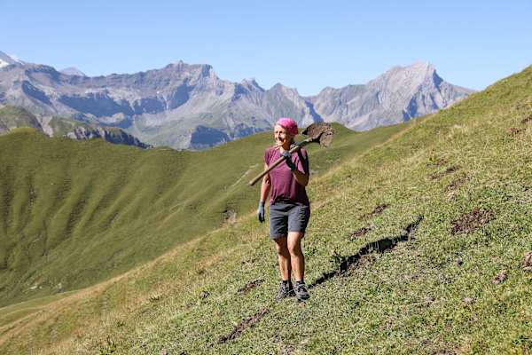 Frau auf der Alm mit Schaufe; Caritas-Bergeinsatz