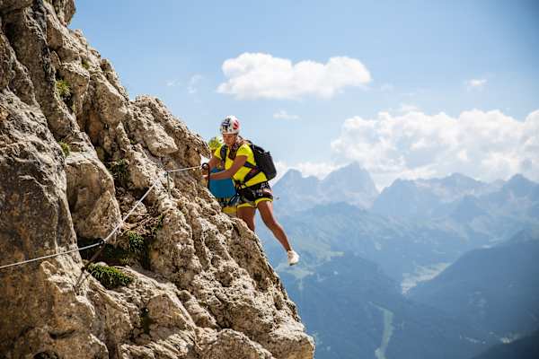 Zwei Personen bei luftigem Quergang im Masaré Klettersteig in den Dolomiten