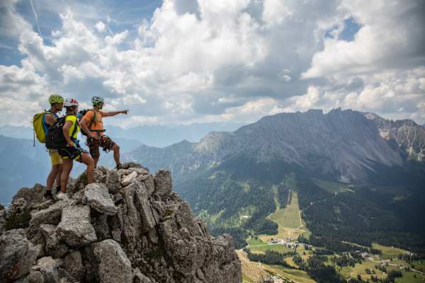 Drei Bergsteiger genießen die Aussicht vom Masaré Klettersteig im Rosengartenmassiv in den Dolomiten