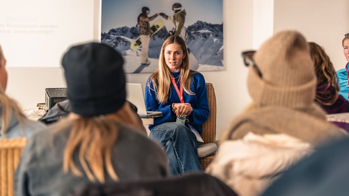 Eine Vortragende in einem Workshop über Podcasts mit langen blonden Haaren.