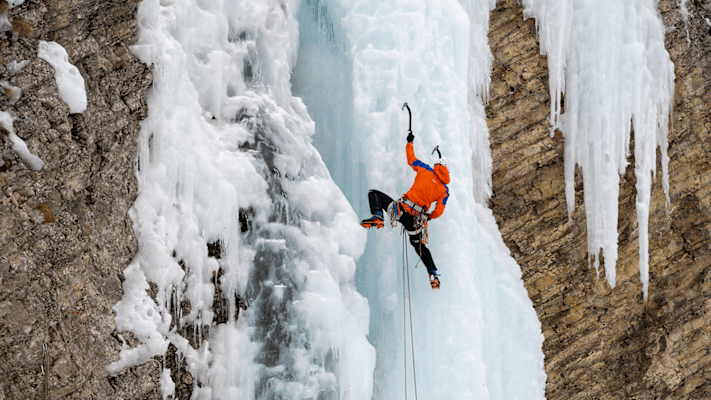 Ein Eiskletterer klettert eine Eiswand hoch und trägt dabei die Eiger Extreme Nordwand 6.0 Kollektion von Mammut.