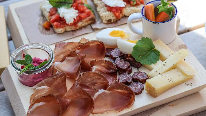 Eine Brettljausn mit Wurst, Käse, Eiern und Gemüse.
